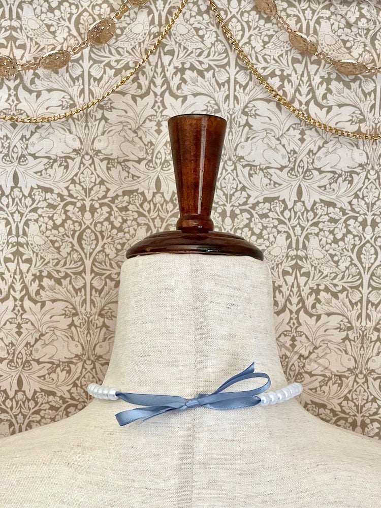 A handmade historically Inspired regency era pearl beaded choker necklace in cornflower blue on a mannequin.