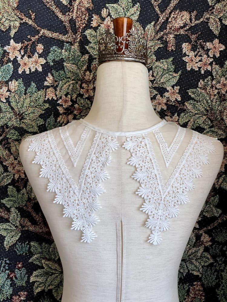 A Historically Inspired Dutch Republic Baroque Era White Venetian Lace Dagger Collar, detachable, with bow closure, on a mannequin.