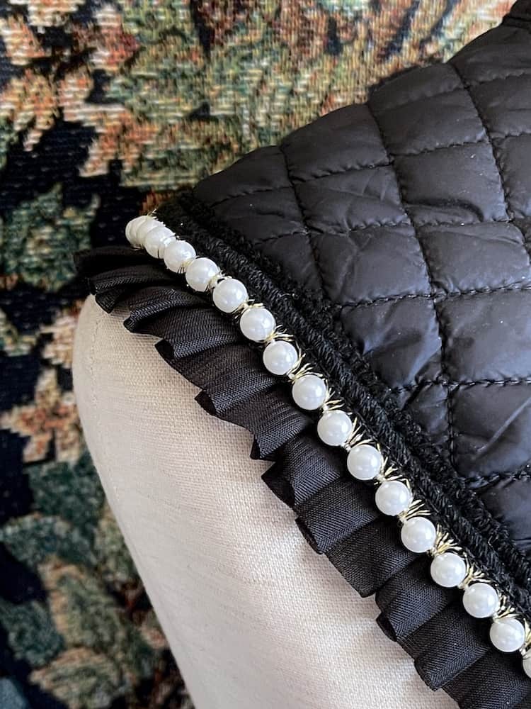 A Historically Inspired Quilted Round Collar with Ruffle & Pearl Trim in Black pictured on a mannequin.