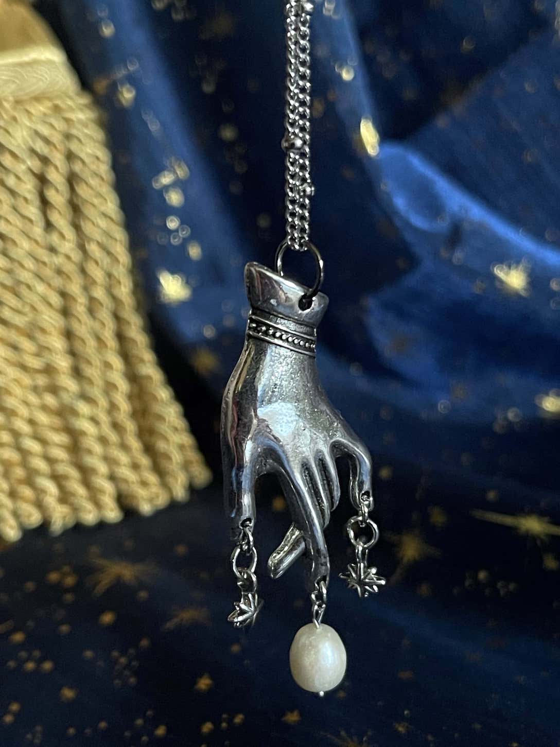 A Handmade Historically Inspired Medieval Hand Pendant Necklace with Real Baroque Pearl Dangle and Celestial Star Charms on a Metal Beaded Chain Necklace in Silver.
