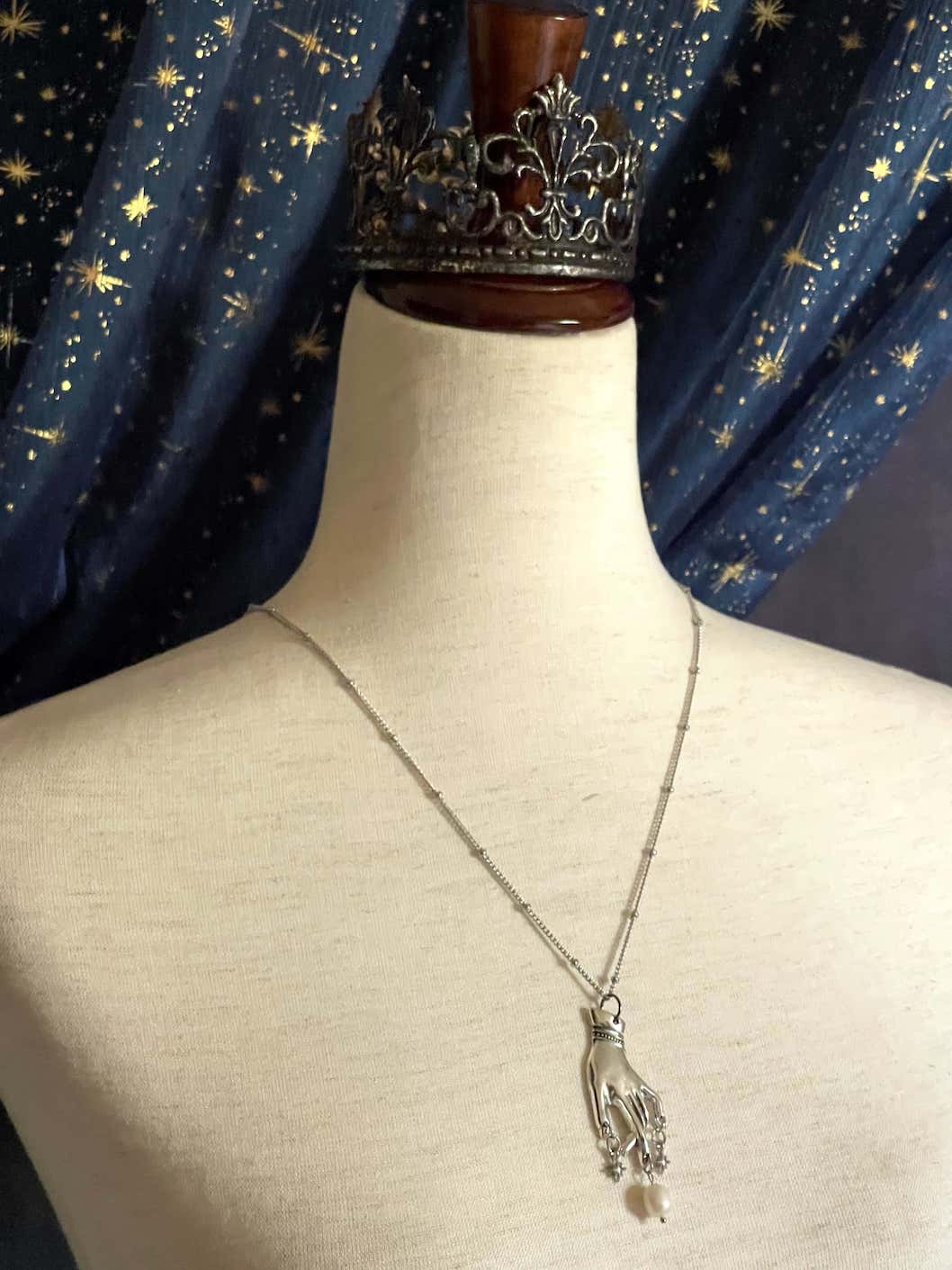 A Handmade Historically Inspired Medieval Hand Pendant Necklace with Real Baroque Pearl Dangle and Celestial Star Charms on a Metal Beaded Chain Necklace in Silver.