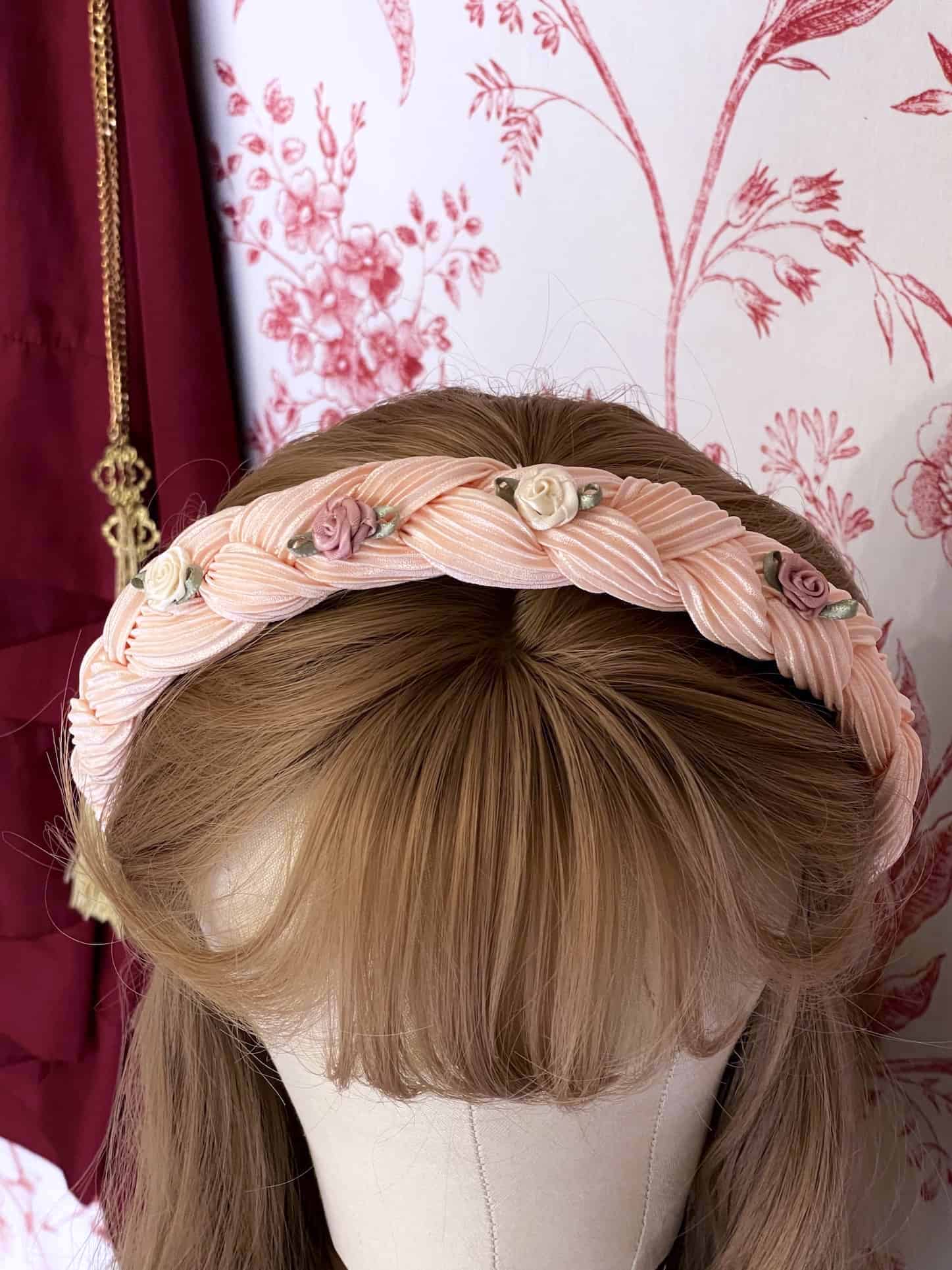 A Historically Inspired Braided Chiffon Rosette Headband in Ballerina Pink, perfect for rococo and regency era fashion.