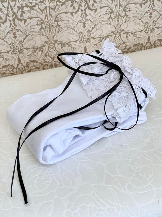 A pair of Historically Inspired Cotton Knee-High Socks with Lace Trim in White & Black. Stockings for any historical era.