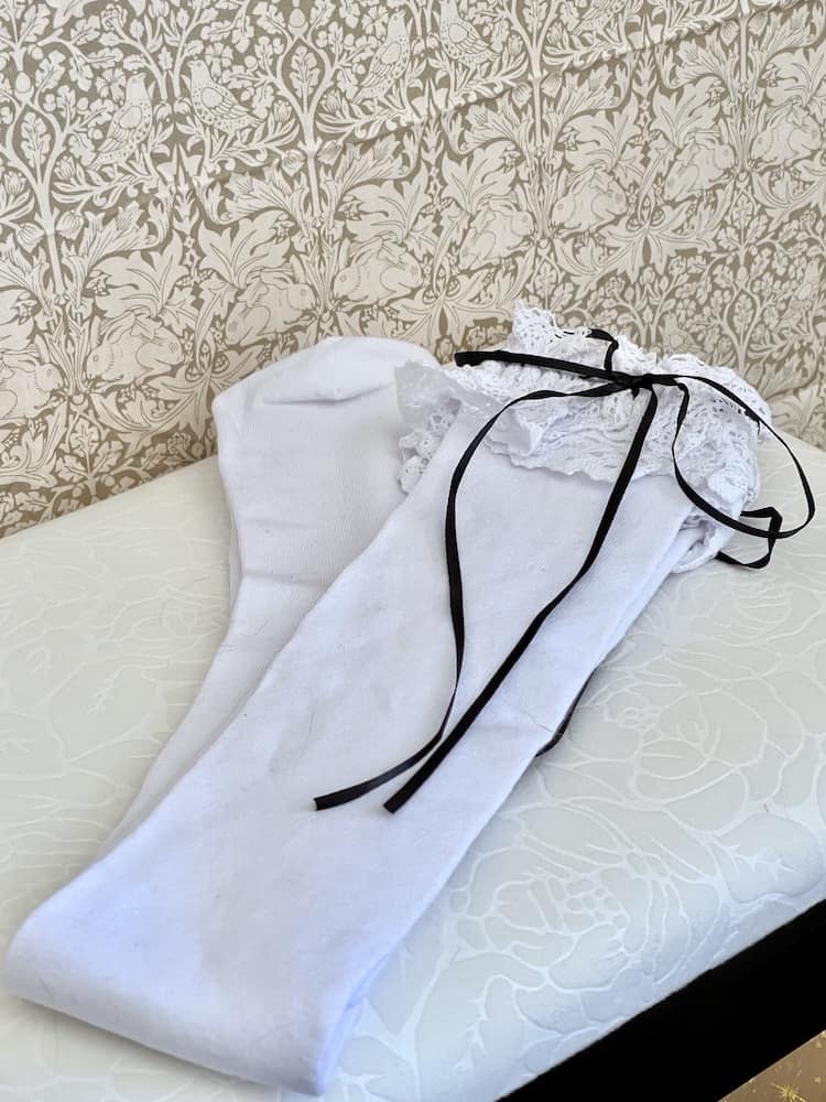 A pair of Historically Inspired Cotton Knee-High Socks with Lace Trim in White & Black. Stockings for any historical era.