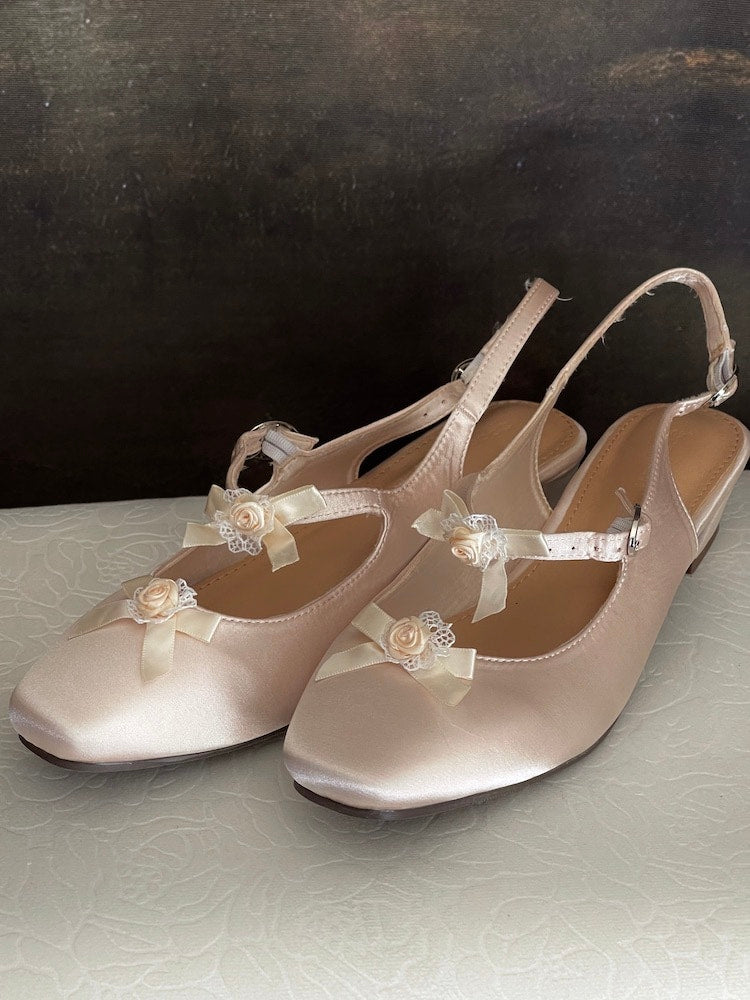 Historically inspired Regency & Rococo Inspired Satin Slipper Heels with Rosette Appliques in Champagne, pictured on a historical painting set.