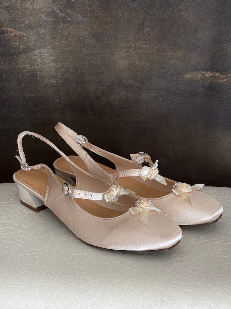 Historically inspired Regency & Rococo Inspired Satin Slipper Heels with Rosette Appliques in Champagne, pictured on a historical painting set.