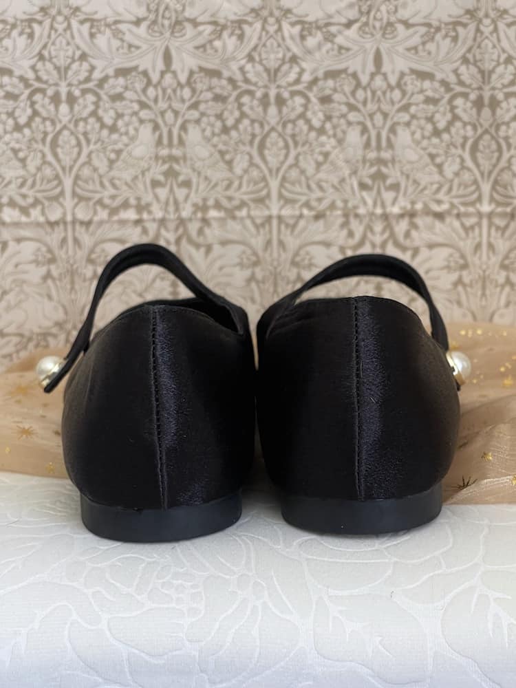 A pair of historically inspired Medieval & Renaissance Satin Pointed Toe Poulaine Flat shoes in Gothic Black with pearl accent.