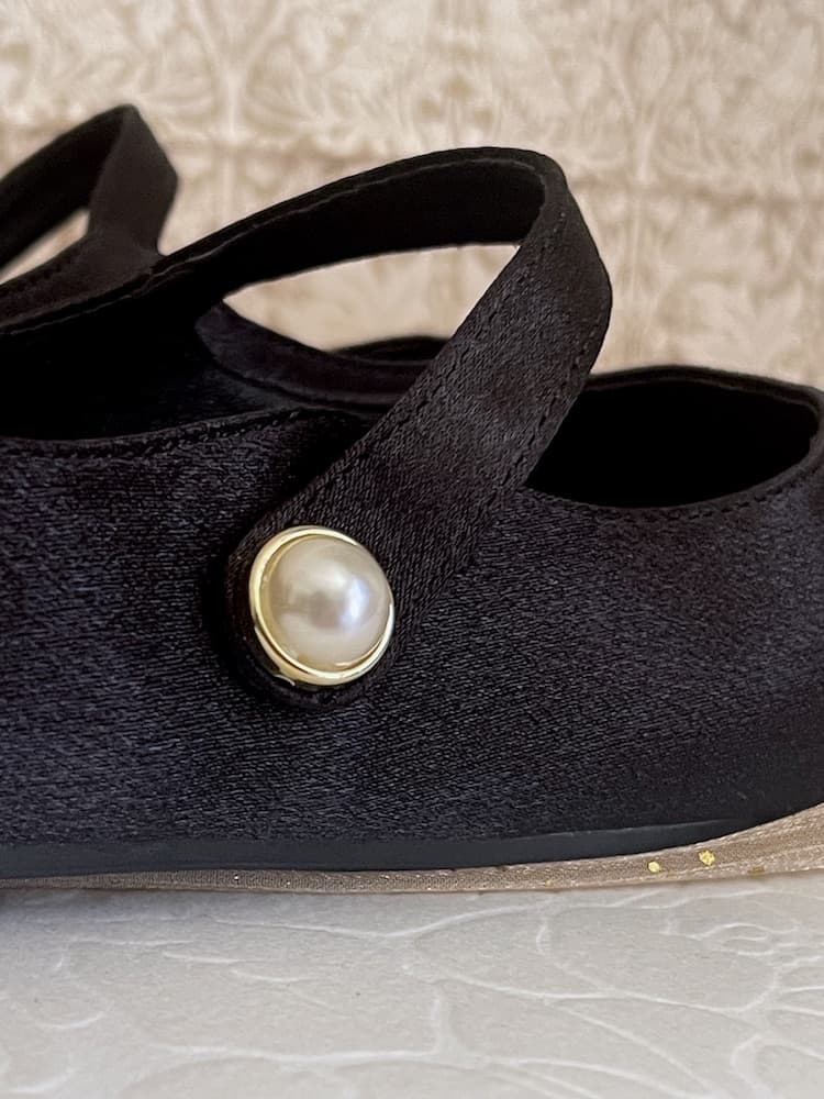 A pair of historically inspired Medieval & Renaissance Satin Pointed Toe Poulaine Flat shoes in Gothic Black with pearl accent.