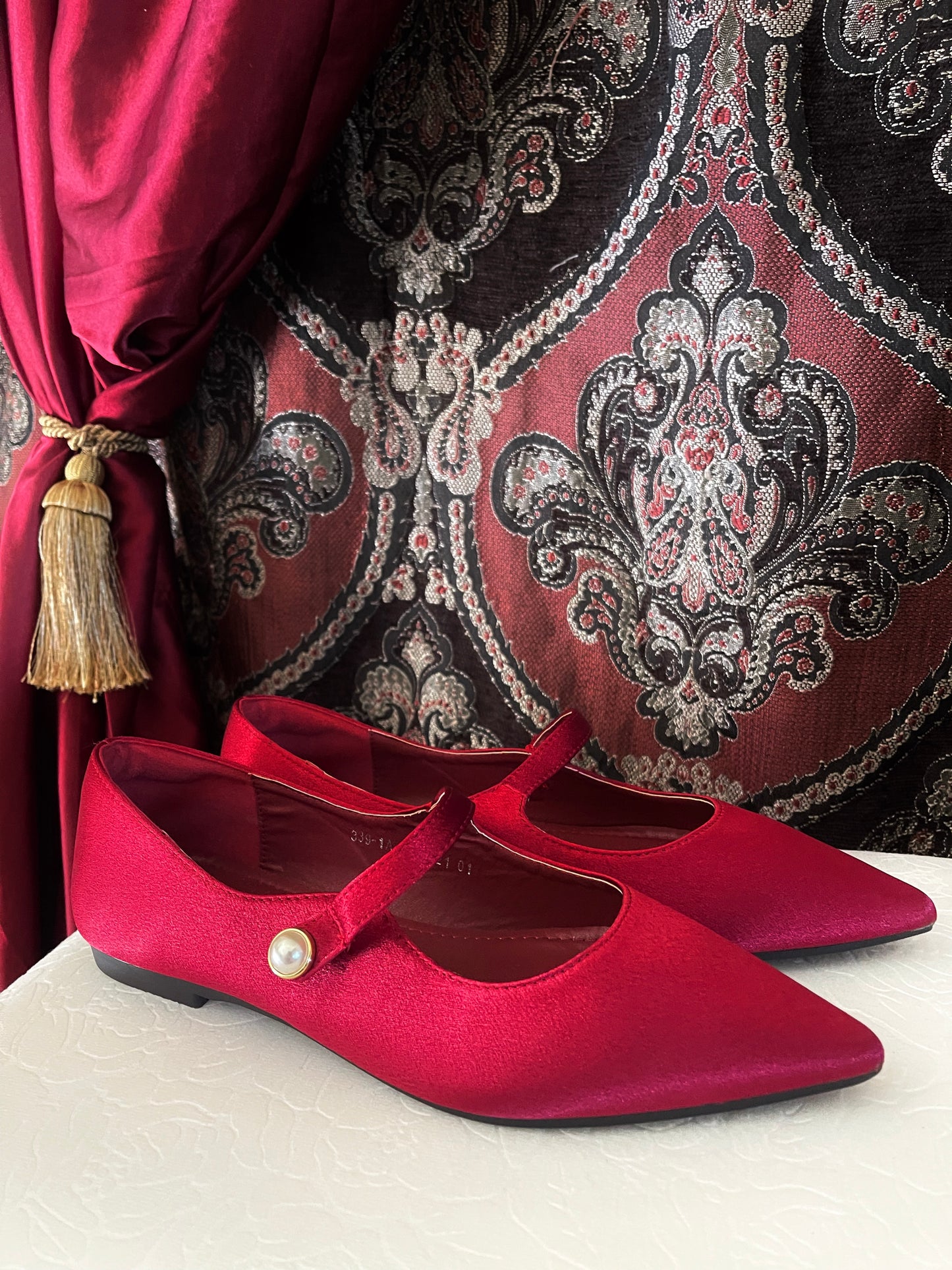 A pair of historically inspired Medieval & Renaissance Satin Pointed Toe Poulaine Flat shoes in Burgundy Red with pearl accent.