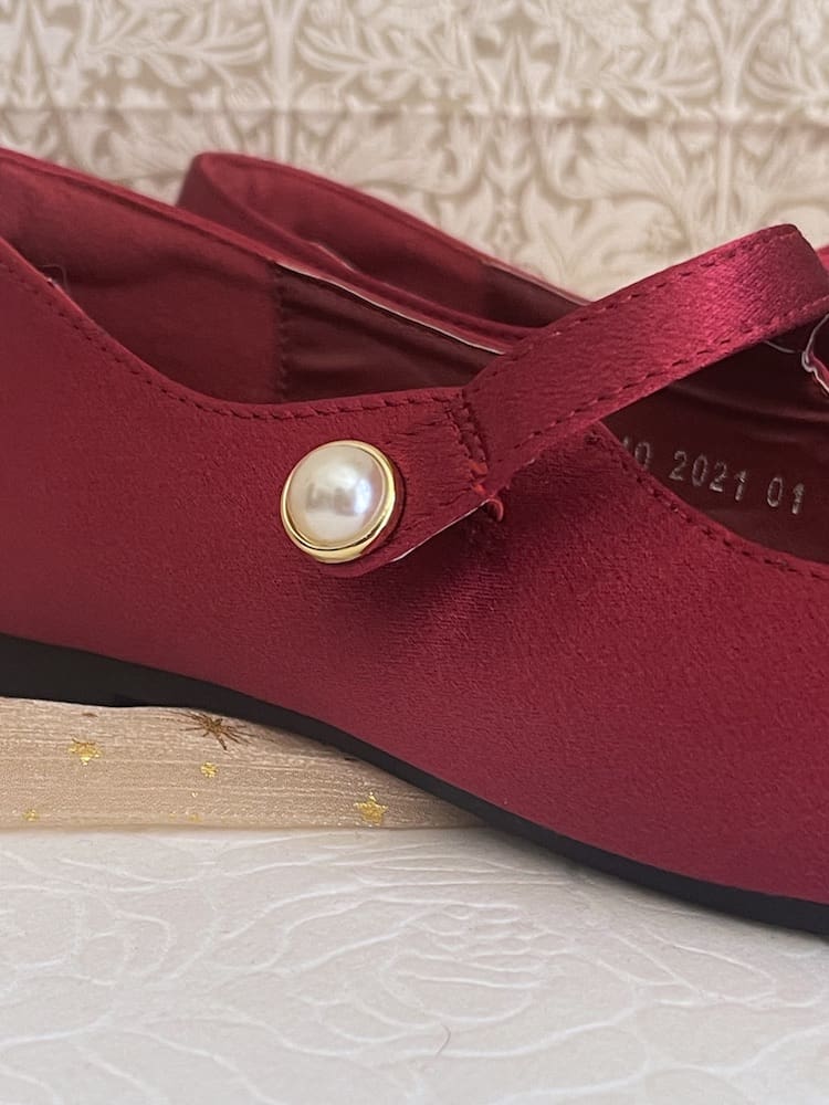 A pair of historically inspired Medieval & Renaissance Satin Pointed Toe Poulaine Flat shoes in Burgundy Red with pearl accent.