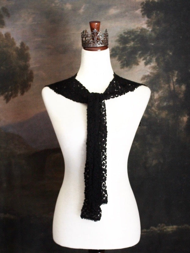 Historically Inspired Floral Crochet Folk Shawl / Capelet in Gothic Black on a mannequin in front of a painting backdrop. Victorian, renaissance, medieval.