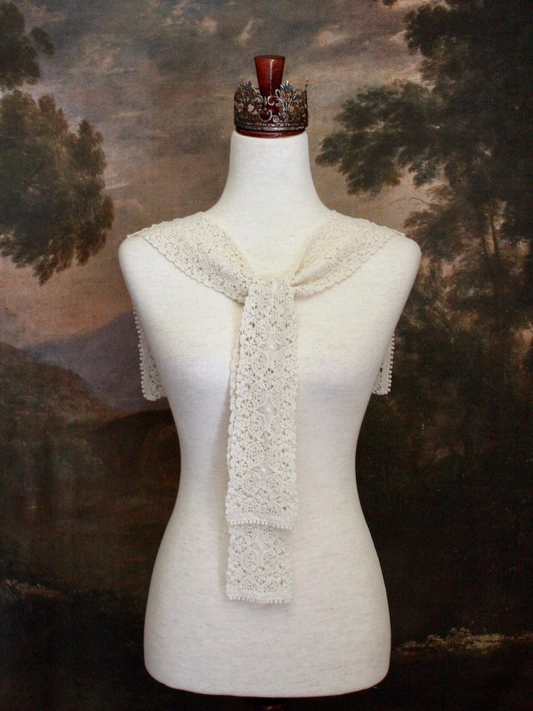 Historically Inspired Floral Crochet Folk Shawl / Capelet in Ivory on a mannequin in front of a painting backdrop. Victorian, renaissance, medieval.
