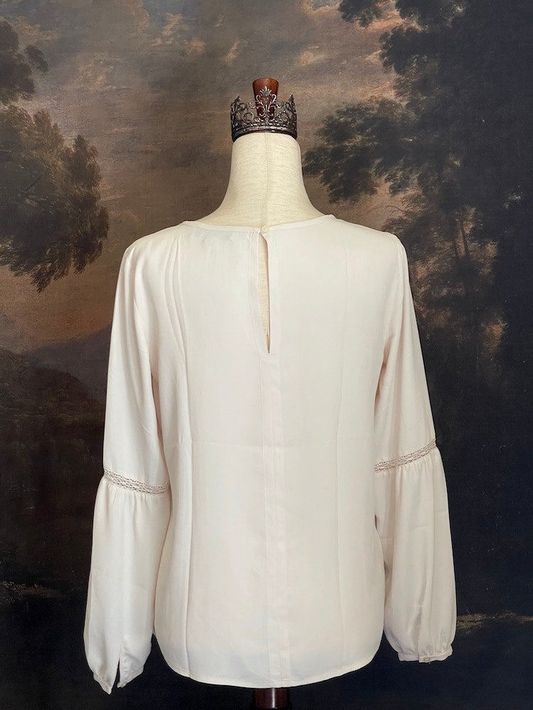 A Historically Inspired tailored Lace Inset Bishop Sleeve Blouse in Ivory, pictured in front of an art history backdrop.