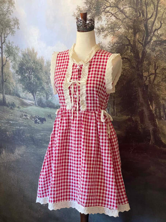 A historically inspired vintage style red and ivory gingham check mini dress with lace trim and ribbon ties.