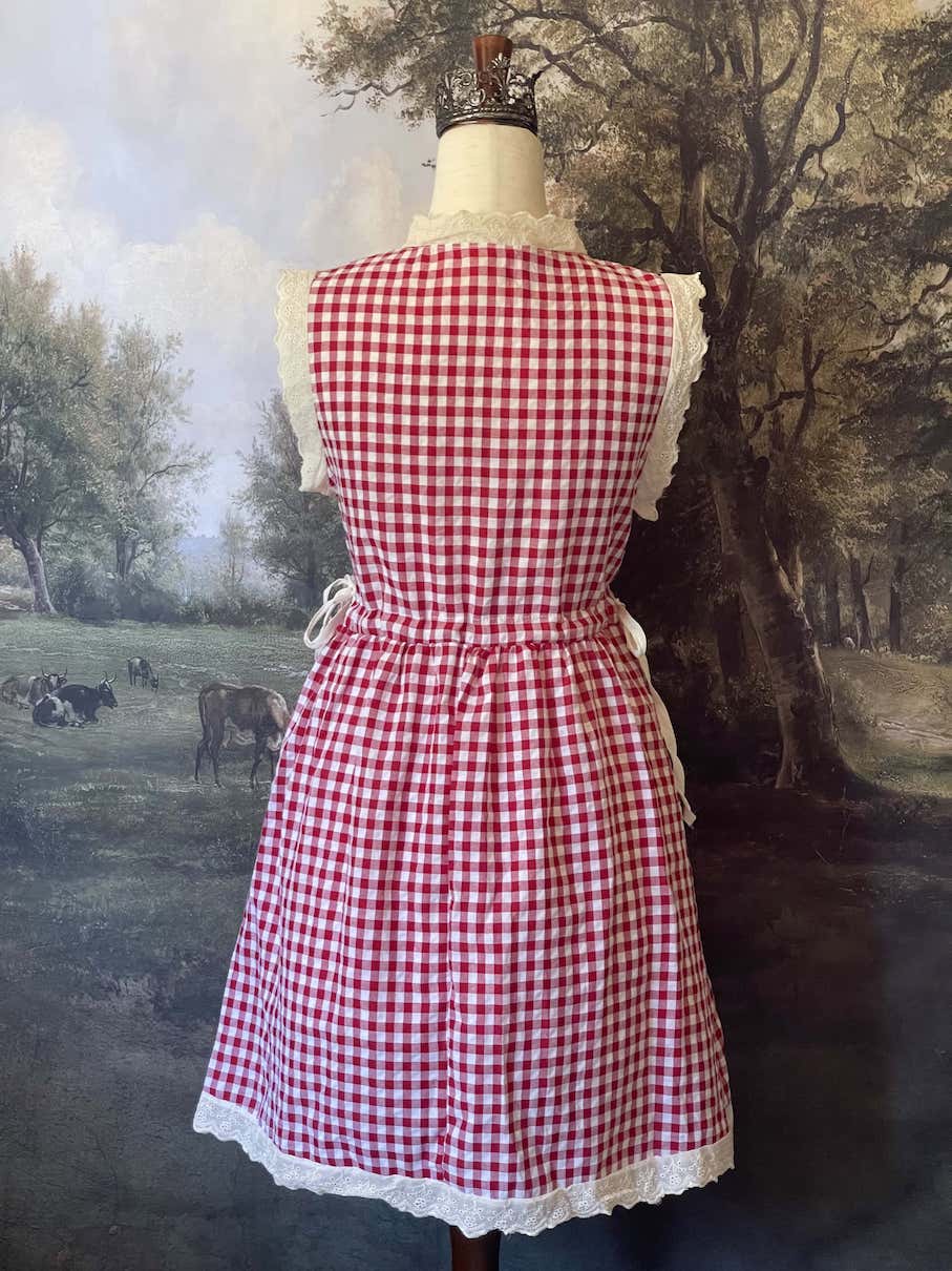 A historically inspired vintage style red and ivory gingham check mini dress with lace trim and ribbon ties.