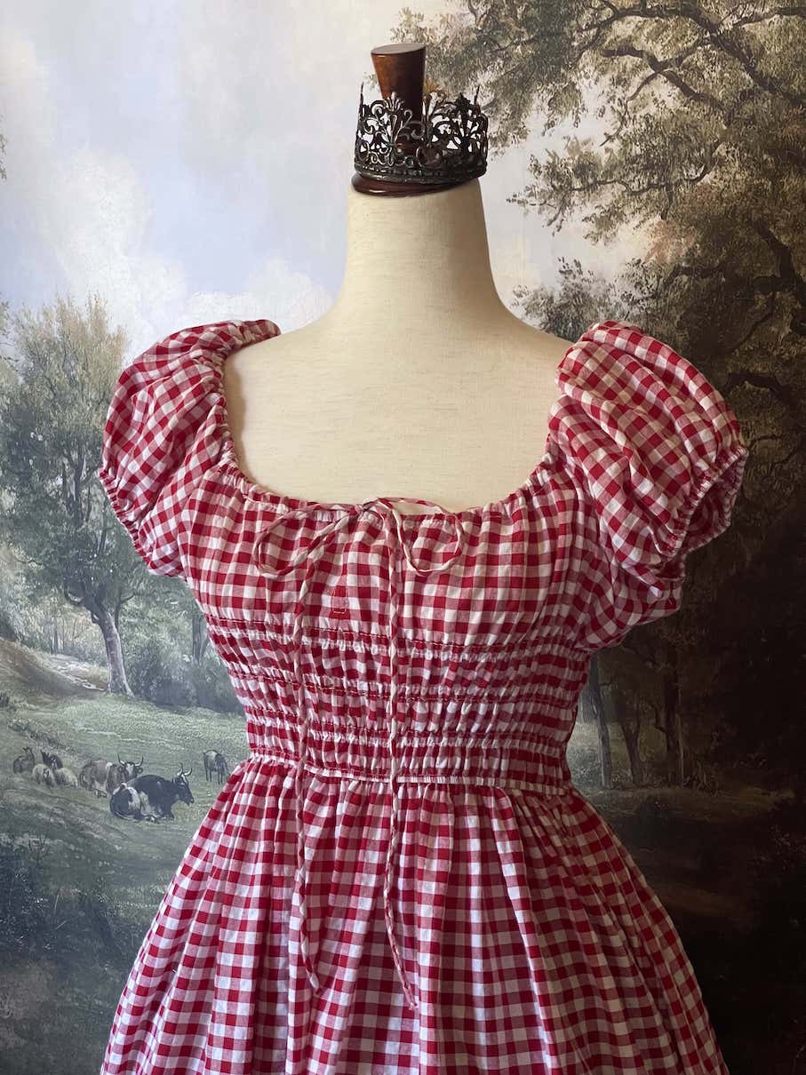 A historically inspired cottage vintage style bardot off shoulder milkmaid red gingham maxi dress with shirred bodice and puff sleeves.