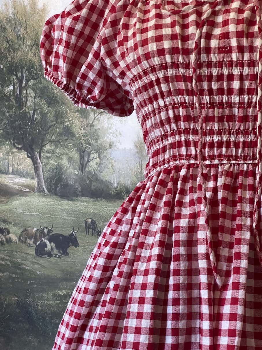 A historically inspired cottage vintage style bardot off shoulder milkmaid red gingham maxi dress with shirred bodice and puff sleeves.