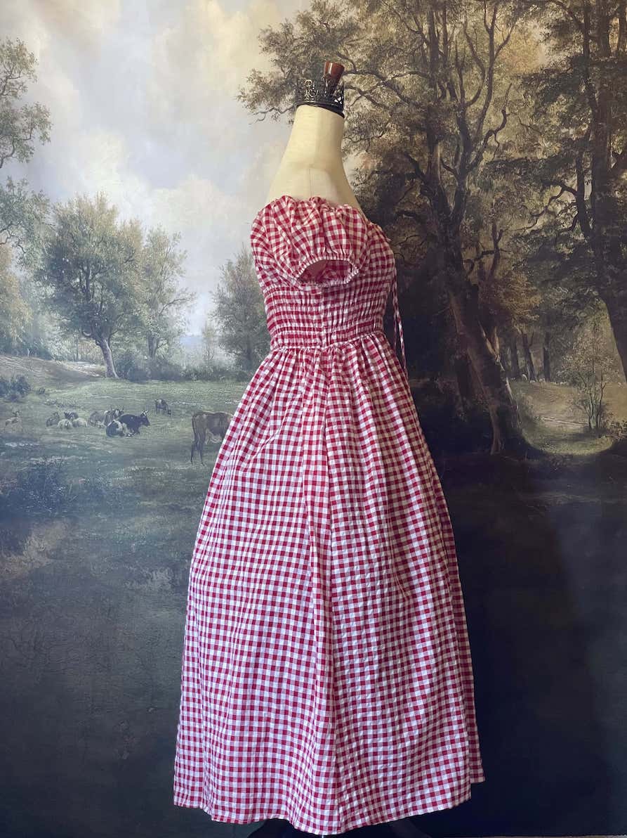 A historically inspired cottage vintage style bardot off shoulder milkmaid red gingham maxi dress with shirred bodice and puff sleeves.