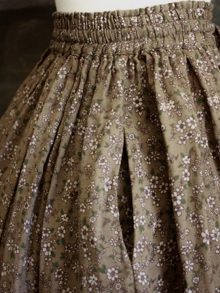 Historically Inspired victorian era peasant turn of the century Printed Floral Cotton Maxi Skirt in Dusty Brown, pictured on a mannequin in front of a classical painting. Pocket detail