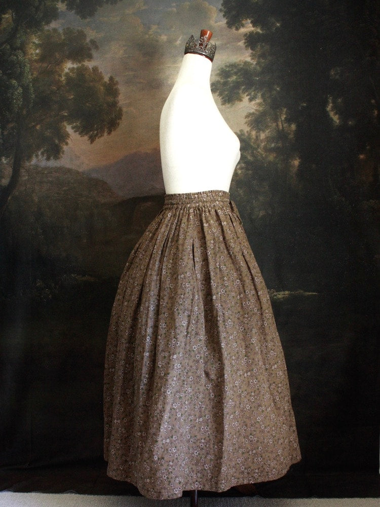 Historically Inspired victorian era peasant turn of the century Printed Floral Cotton Maxi Skirt in Dusty Brown, pictured on a mannequin in front of a classical painting.