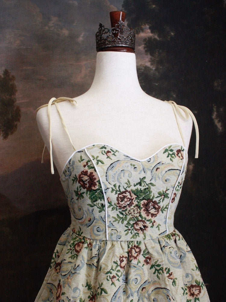 A Historically Inspired Coquette Rococo Baroque Ornate Rose Gobelin Tapestry Mini Dress in front of a historical backdrop.