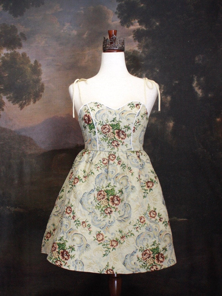 A Historically Inspired Coquette Rococo Baroque Ornate Rose Gobelin Tapestry Mini Dress in front of a historical backdrop.