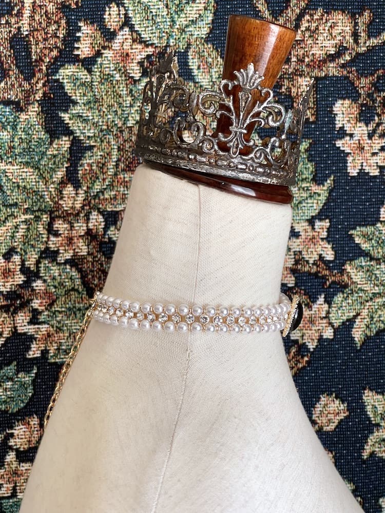 A Historically inspired renaissance tudor baroque rococo regency victorian edwardian pearl beaded crystal accent choker necklace in black is pictured on a mannequin.