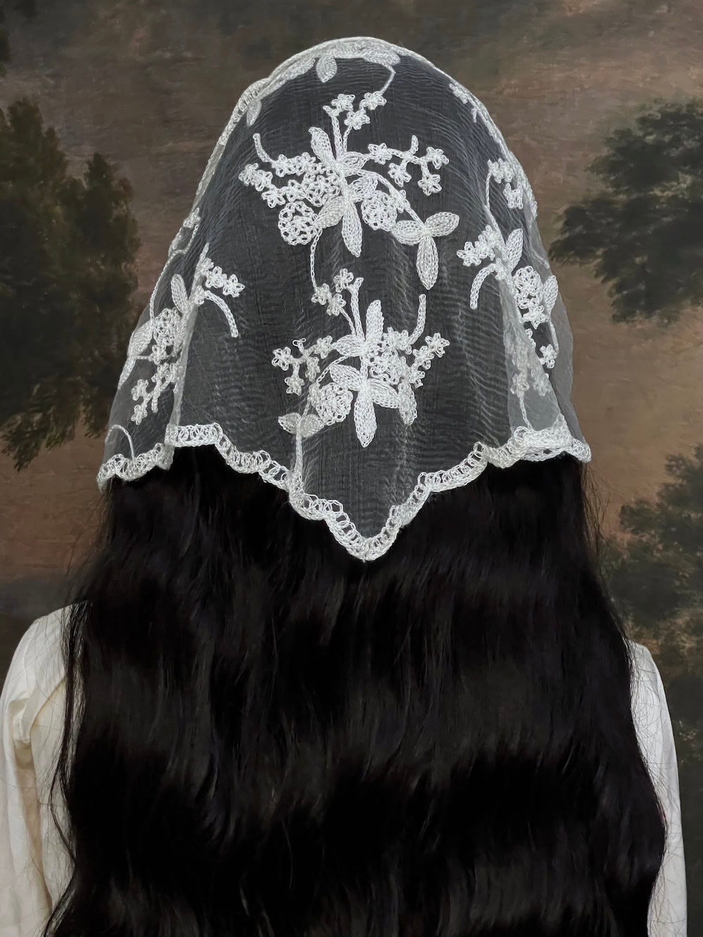 Mannequin wearing a vintage style ivory lace headscarf babushka triangle headdress made from floral embroidery lace against an art history background