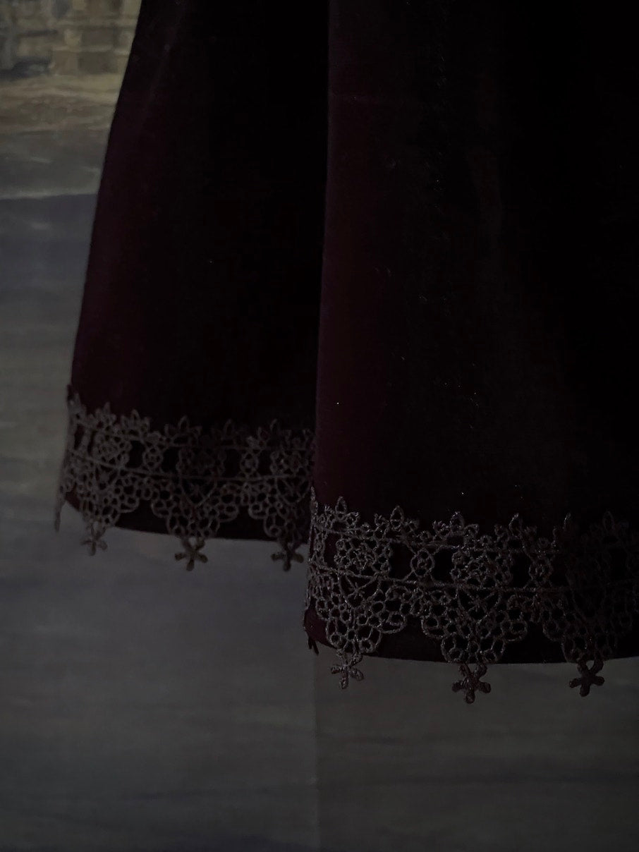 A Historically Inspired Renaissance and Medieval Style Gothic Lace-Trimmed Velvet Mini Skirt in Black with Bow appliques.