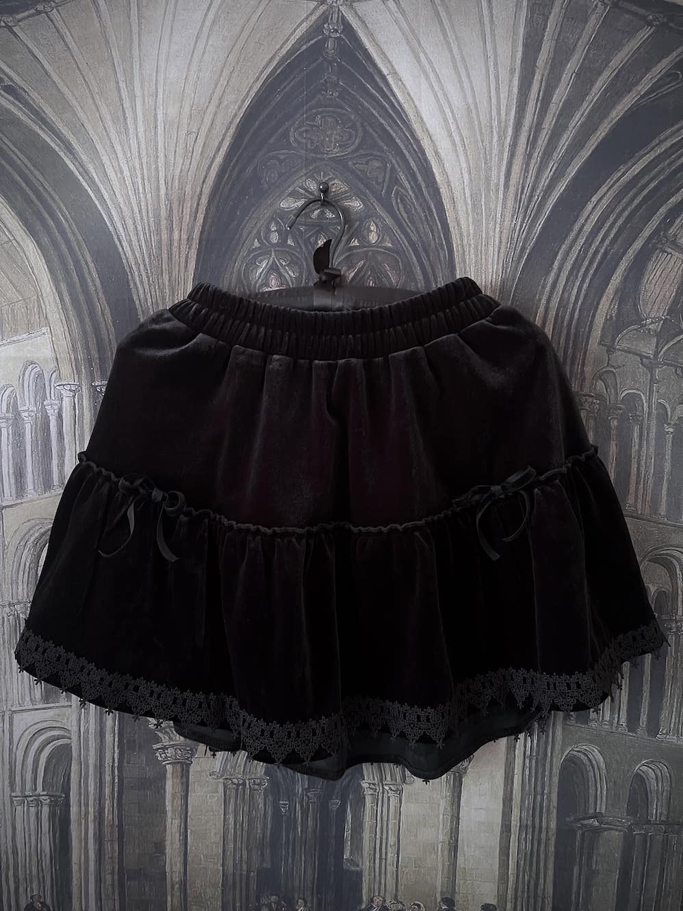 A Historically Inspired Renaissance and Medieval Style Gothic Lace-Trimmed Velvet Mini Skirt in Black with Bow appliques.