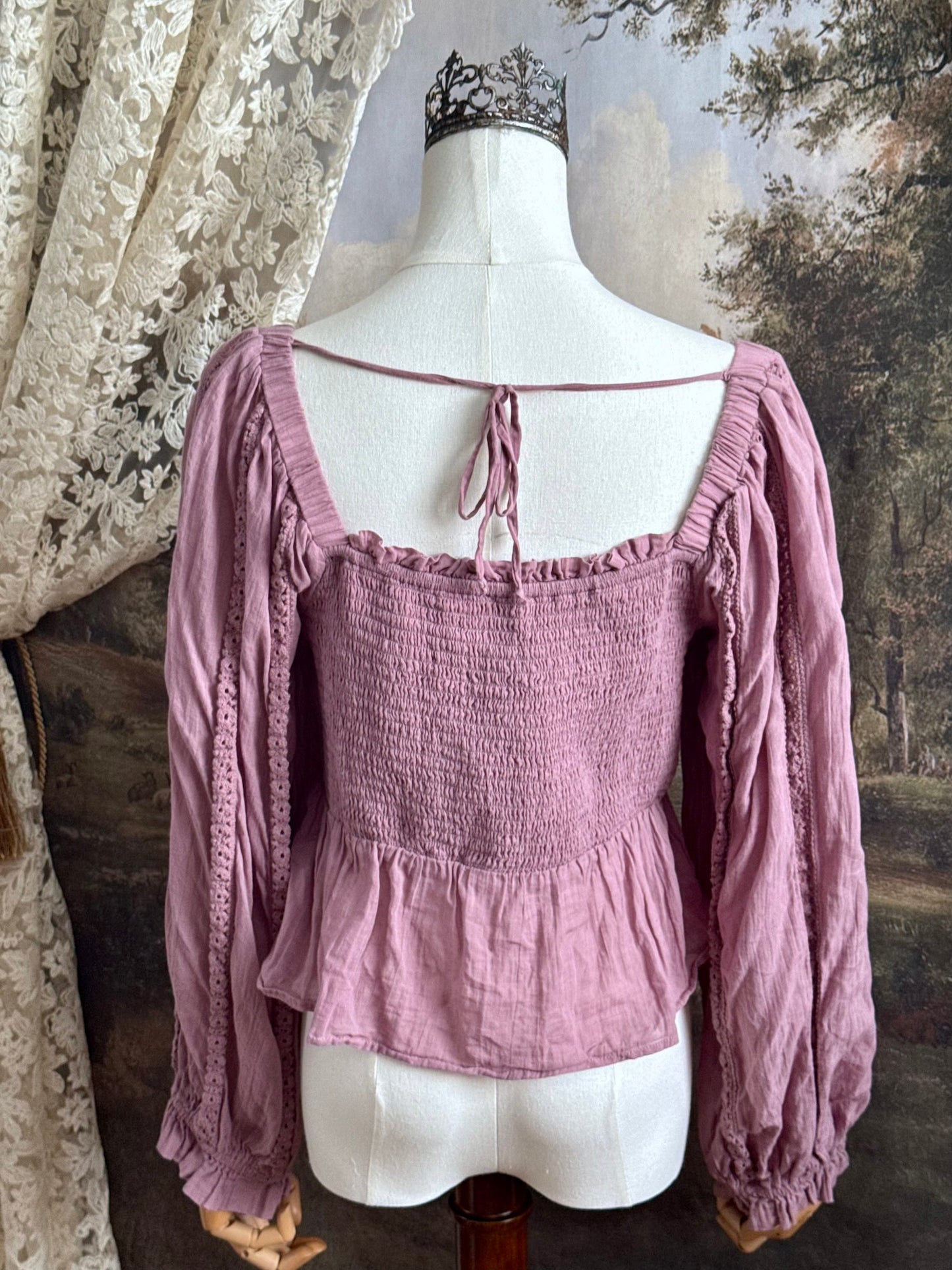 A historically inspired mauve pink shirred cotton peasant blouse with long bishop sleeves pictured on a mannequin