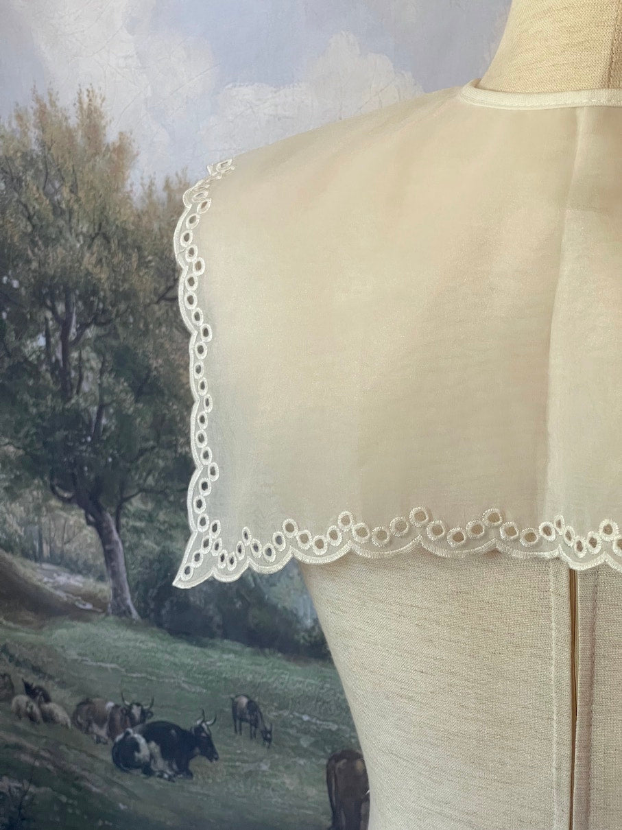 A Historically inspired edwardian and victorian and baroque era removeable collar shawl with floral embroidery and a scalloped hem in white.