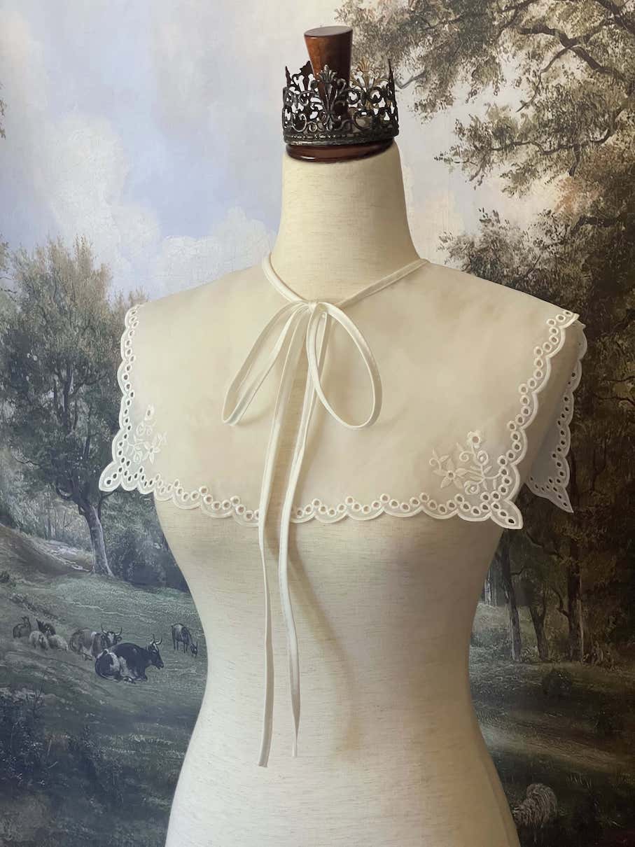 A Historically inspired edwardian and victorian and baroque era removeable collar shawl with floral embroidery and a scalloped hem in white.