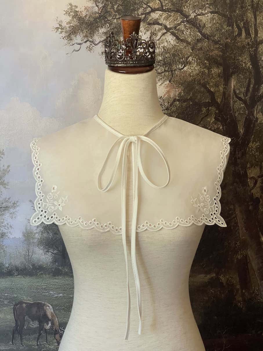 A Historically inspired edwardian and victorian and baroque era removeable collar shawl with floral embroidery and a scalloped hem in white.