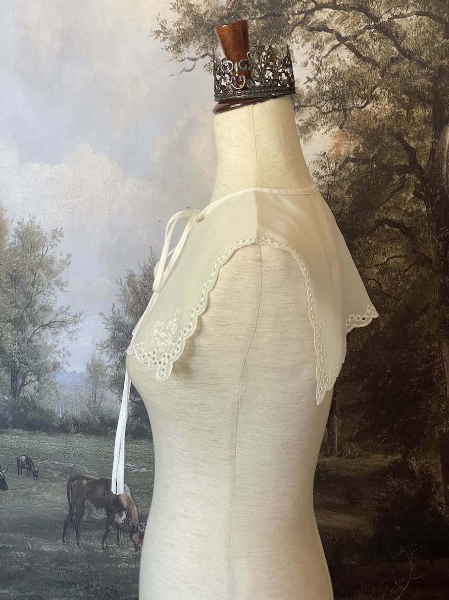 A Historically inspired edwardian and victorian and baroque era removeable collar shawl with floral embroidery and a scalloped hem in white.