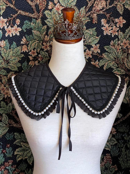 A Historically Inspired Quilted Round Collar with Ruffle & Pearl Trim in Black pictured on a mannequin.