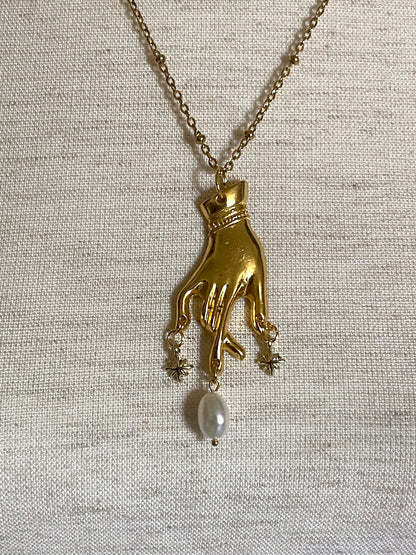 A Handmade Historically Inspired Medieval Hand Pendant Necklace with Real Baroque Pearl Dangle and Celestial Star Charms on a Metal Beaded Chain Necklace in Gold.