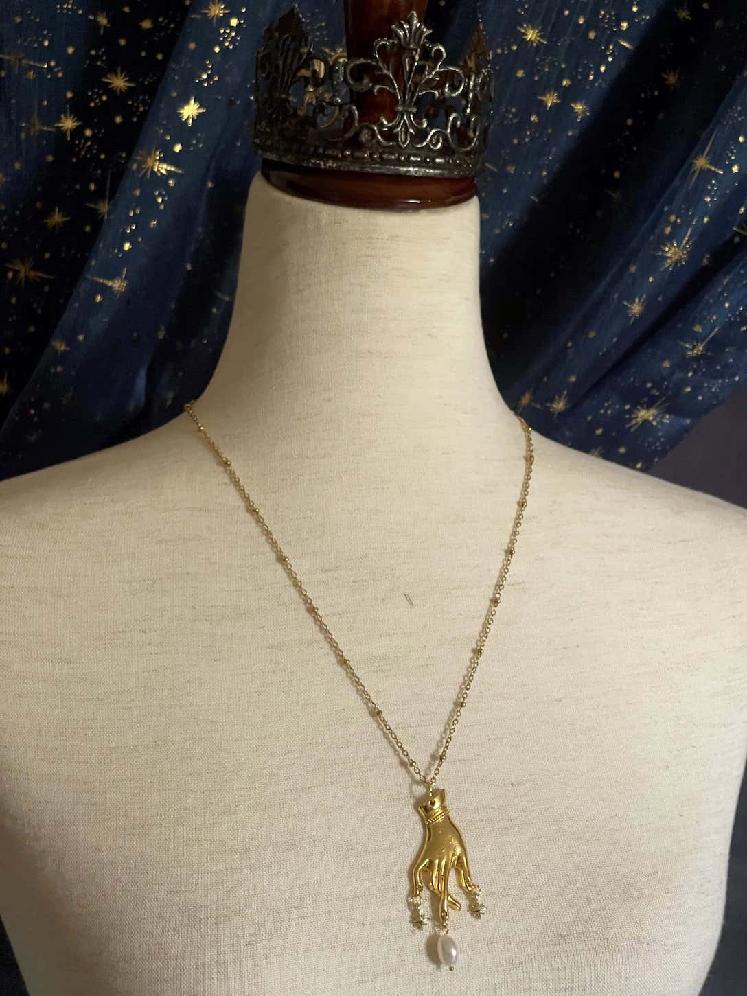 A Handmade Historically Inspired Medieval Hand Pendant Necklace with Real Baroque Pearl Dangle and Celestial Star Charms on a Metal Beaded Chain Necklace in Gold.