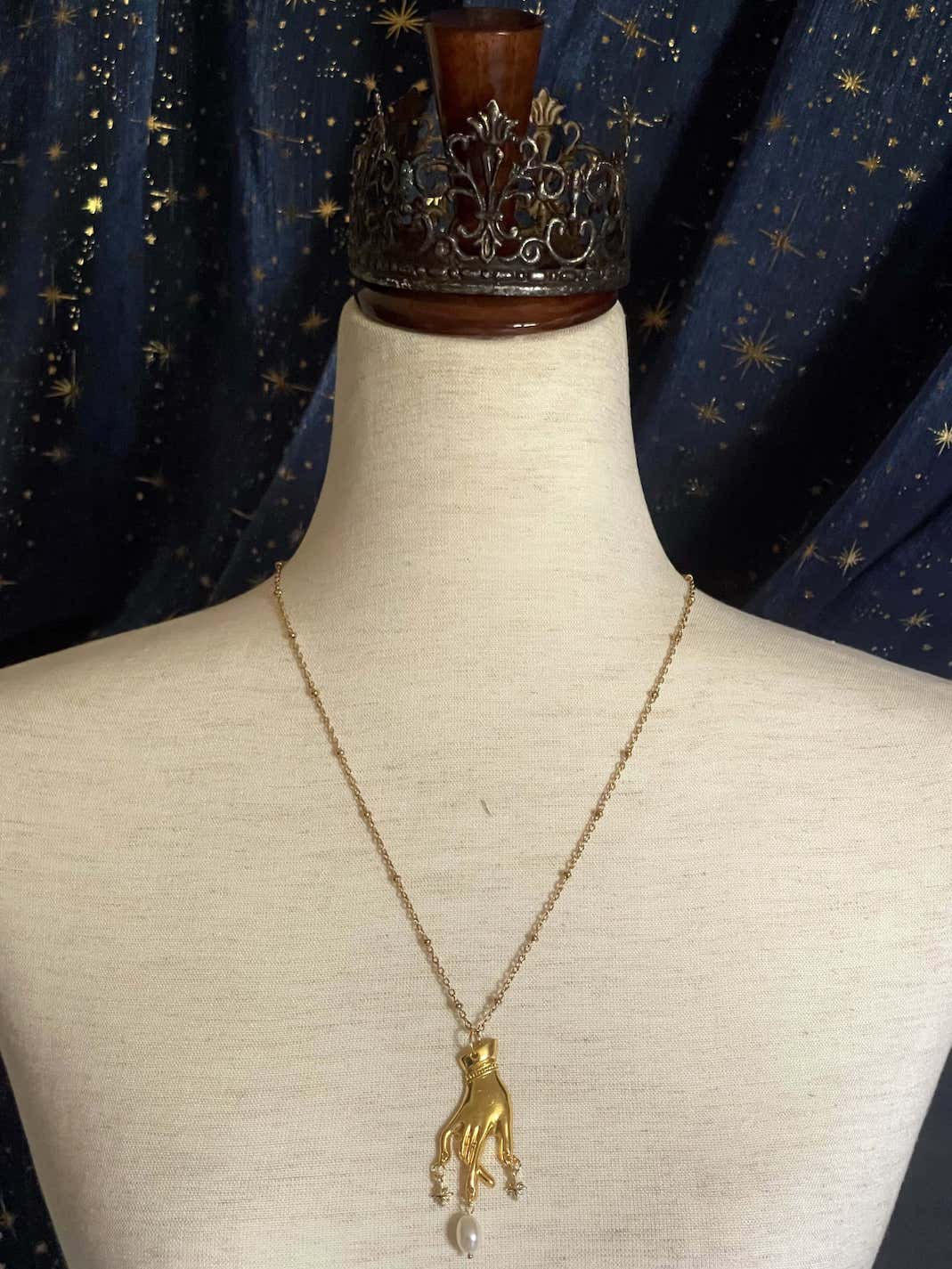 A Handmade Historically Inspired Medieval Hand Pendant Necklace with Real Baroque Pearl Dangle and Celestial Star Charms on a Metal Beaded Chain Necklace in Gold.
