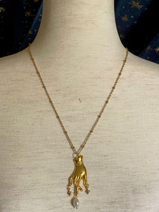 A Handmade Historically Inspired Medieval Hand Pendant Necklace with Real Baroque Pearl Dangle and Celestial Star Charms on a Metal Beaded Chain Necklace in Gold.