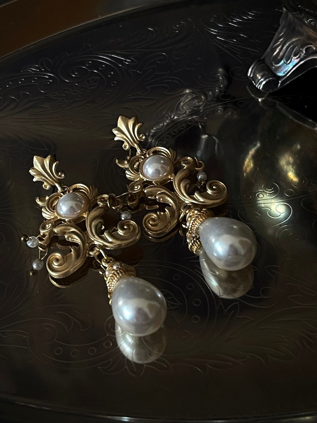 A pair of gold-colored Renaissance Inspired Ornate Flourish Earrings with Pearl Drops.