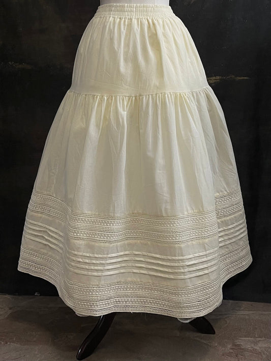 An ivory cotton victorian and baroque style historical fashion inspired petticoat maxi skirt with crochet lace inlay and pleated details 