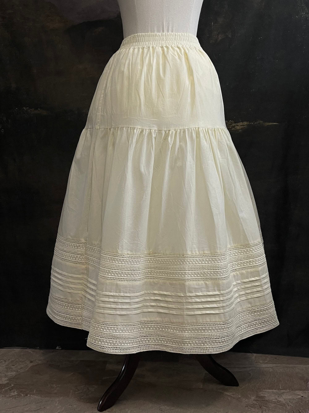 An ivory cotton victorian and baroque style historical fashion inspired petticoat maxi skirt with crochet lace inlay and pleated details 