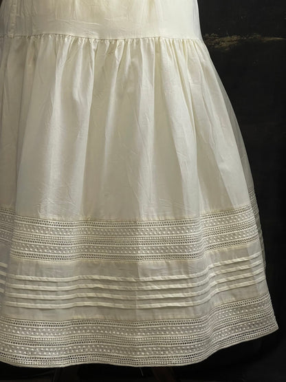 An ivory cotton victorian and baroque style historical fashion inspired petticoat maxi skirt with crochet lace inlay and pleated details 
