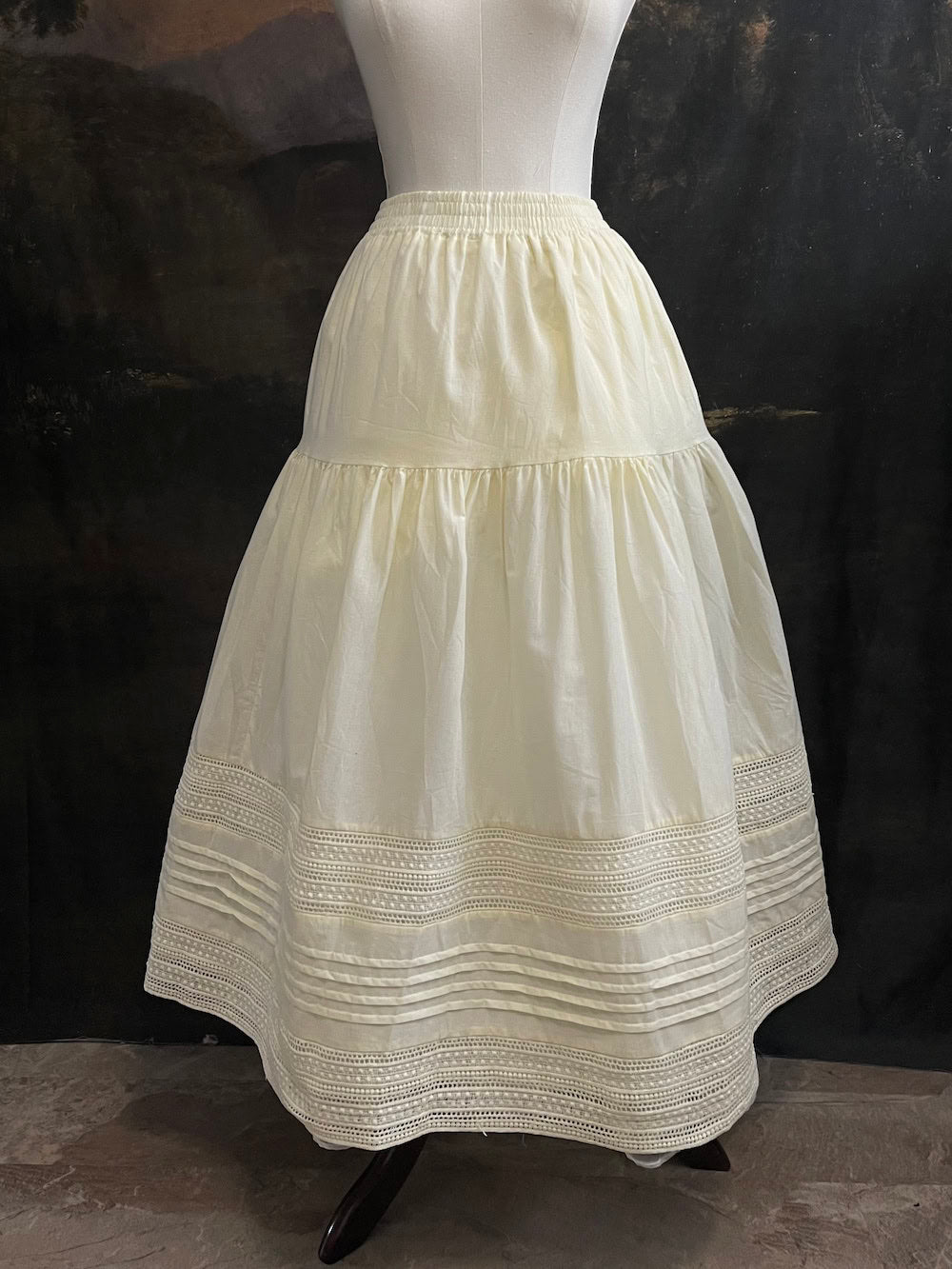 An ivory cotton victorian and baroque style historical fashion inspired petticoat maxi skirt with crochet lace inlay and pleated details 