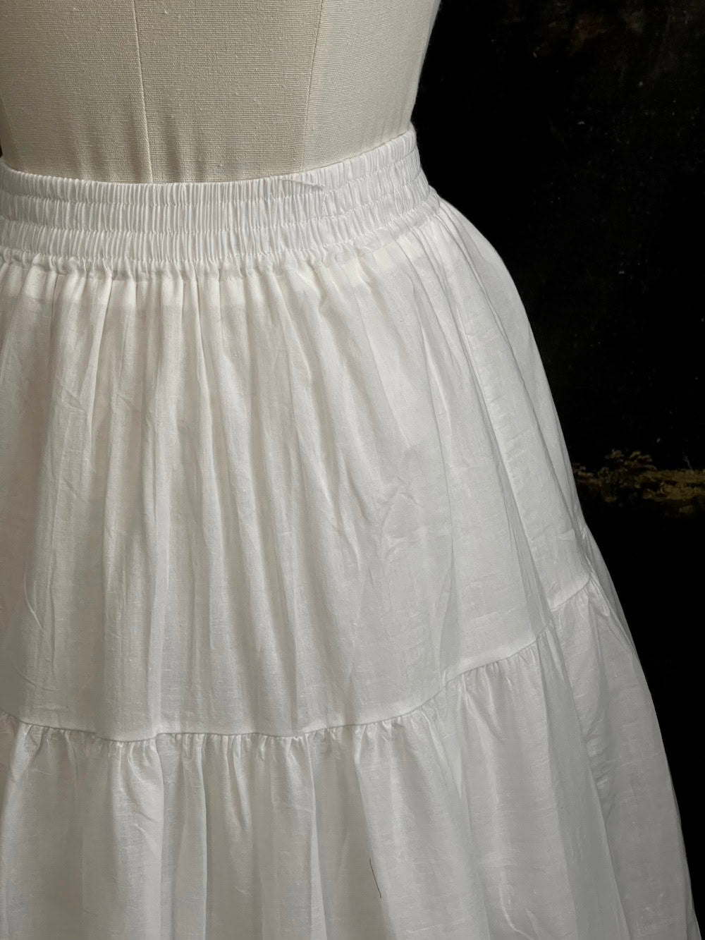 A white cotton victorian and baroque style historical fashion inspired petticoat maxi skirt with crochet lace inlay and pleated details 