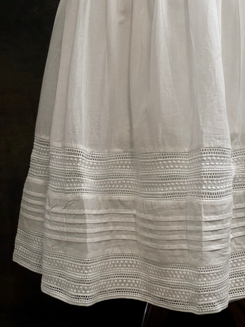 A white cotton victorian and baroque style historical fashion inspired petticoat maxi skirt with crochet lace inlay and pleated details 