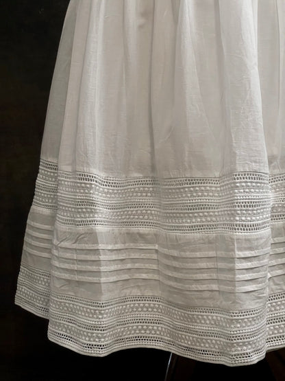 A white cotton victorian and baroque style historical fashion inspired petticoat maxi skirt with crochet lace inlay and pleated details 