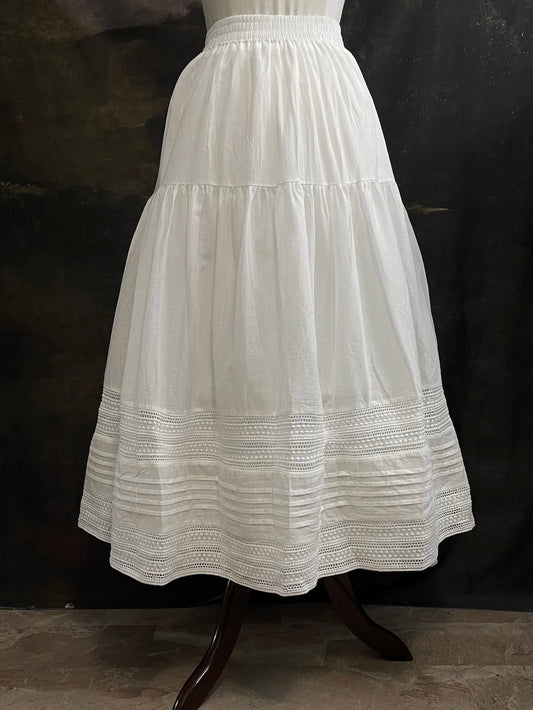A white cotton victorian and baroque style historical fashion inspired petticoat maxi skirt with crochet lace inlay and pleated details 