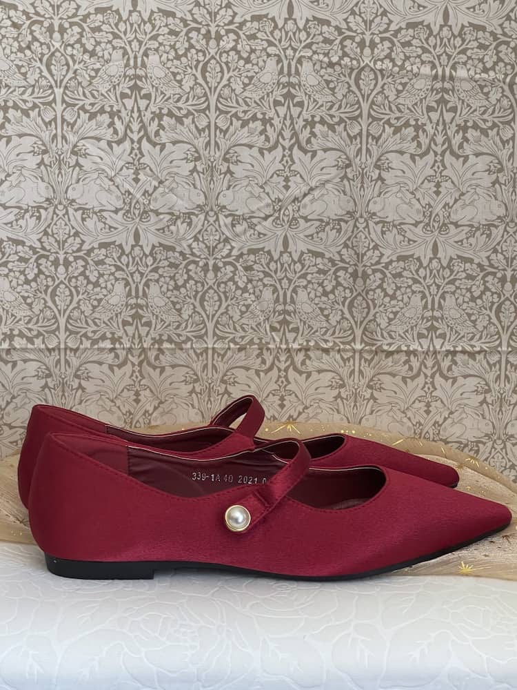 A pair of historically inspired Medieval & Renaissance Satin Pointed Toe Poulaine Flat shoes in Burgundy Red with pearl accent.